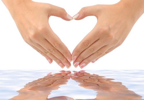 Heart made of hands and water isolated on white background